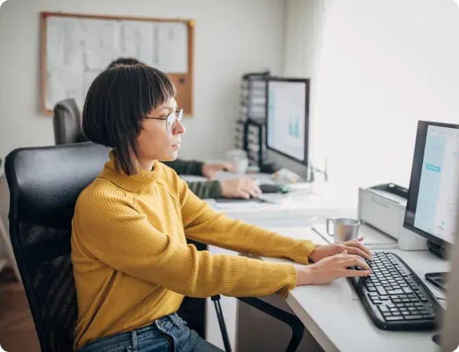 Woman working at a desktop computer in an office
